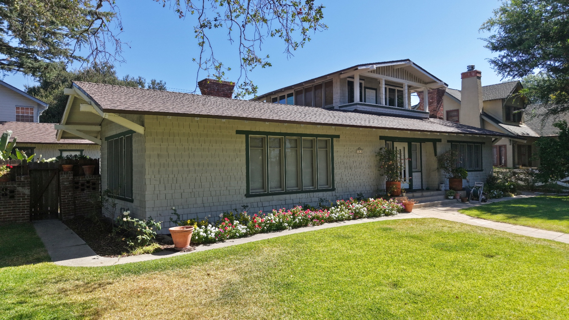 Finished dark grey roof on a light-colored residential home