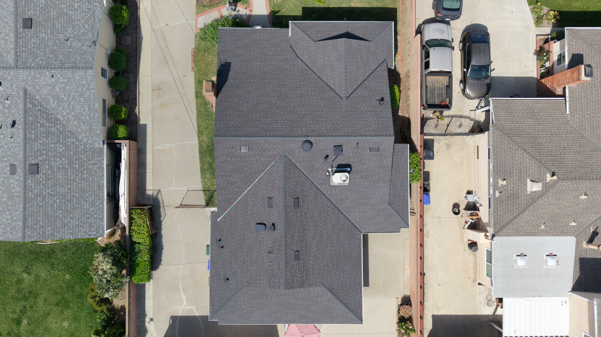 Top-down aerial view of a completed grey shingle roof
