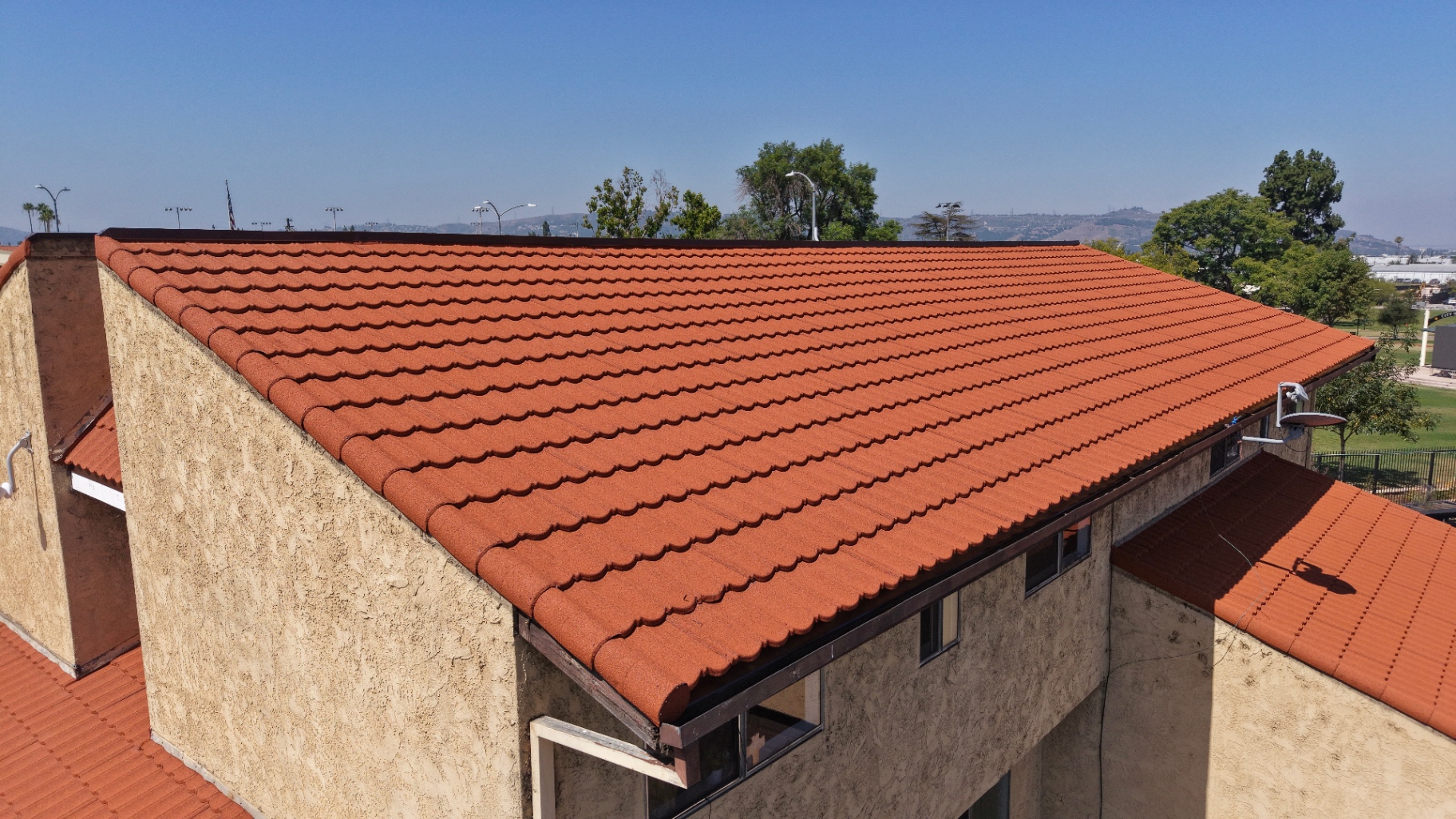 Finished red tile roof on a stucco building